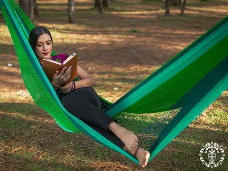 hamac mexicain XL en nylon, vert, vue de face avec une femme couché dans la diagonale qui lit un livre