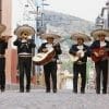 Groupe de Mariachi en costume avec leur guitare et au Mexique dans une ruelle