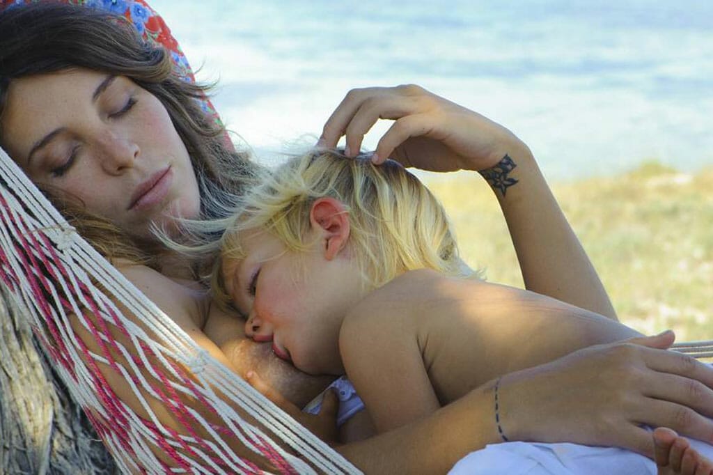 Femme qui dort avec son bébé dans un hamac