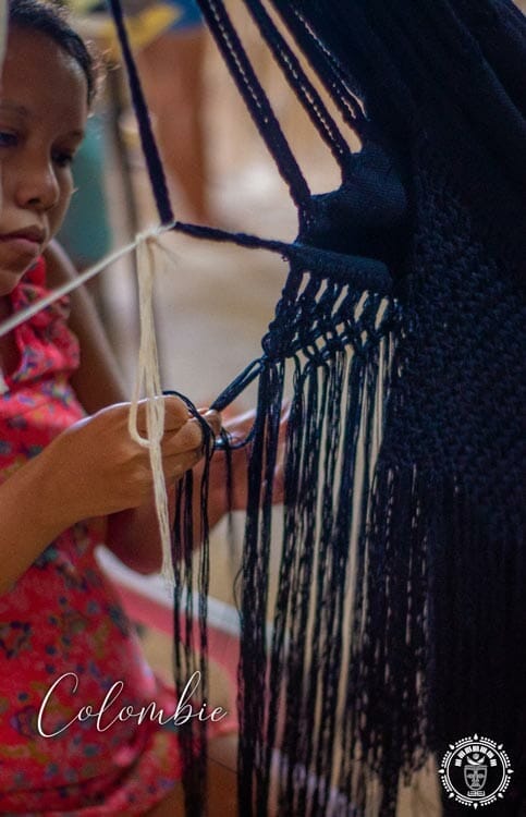 Artisane Colombienne qui tisse à la main les franges d'un hamac Colombien vue de coté