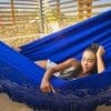 hamac bleu foncé XXL Premium de Colombie vue de face en gros plan avec une femme allongée à l'intérieur