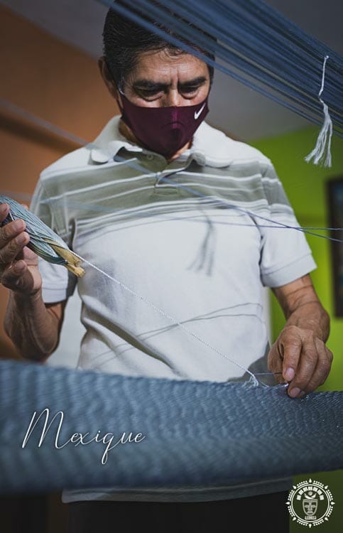 Un artisan mexicain, vue de face, qui tisse un hamac gris