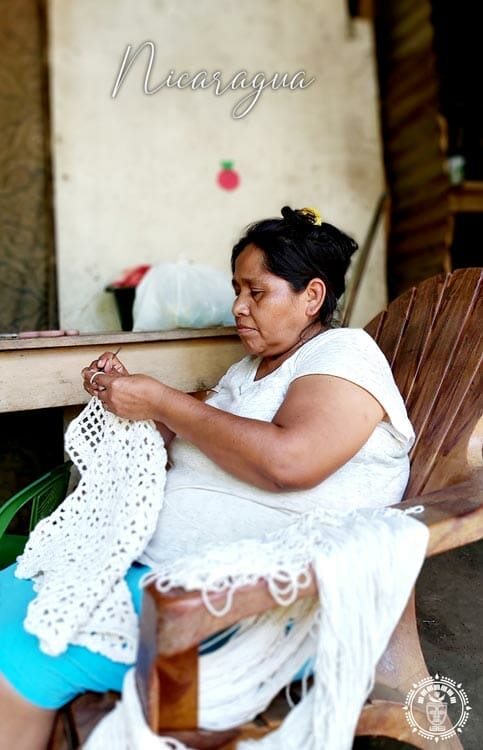 Femme assise qui tisse les franges d'un hamac du Nicaragua, vue de coté