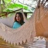 hamac à barre de luxe du Nicaragua vue de coté, gros plan sur les franges avec une femme à l'intérieur