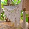 hamac à barre du Nicaragua en coton L, écru vu de coté en gros plan sur les franges et les décorations en bois