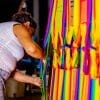 artisane Colombienne qui se penche pour tisser un hamac Colombien Multicolore vue de coté