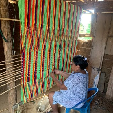 image d'une femme Wayuu qui tisse avec ses mains un hamac Wayuu